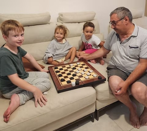 Playing checkers with his grandchildren